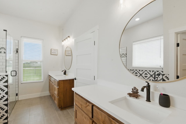 full bath featuring a sink, tile patterned floors, a stall shower, and two vanities
