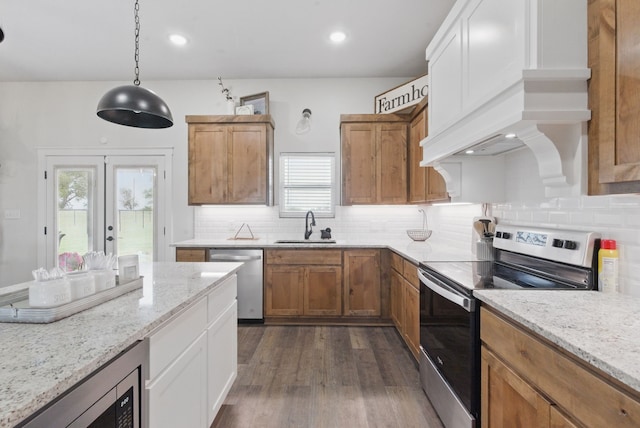 kitchen with backsplash, dark wood-style flooring, appliances with stainless steel finishes, a sink, and white cabinets