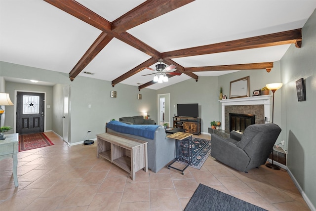 living area featuring a ceiling fan, visible vents, a tile fireplace, baseboards, and lofted ceiling with beams