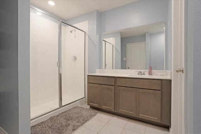 full bath with vanity, tile patterned floors, and a stall shower