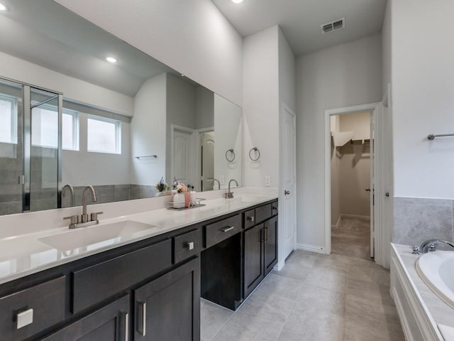 bathroom featuring a sink, a shower stall, double vanity, and visible vents