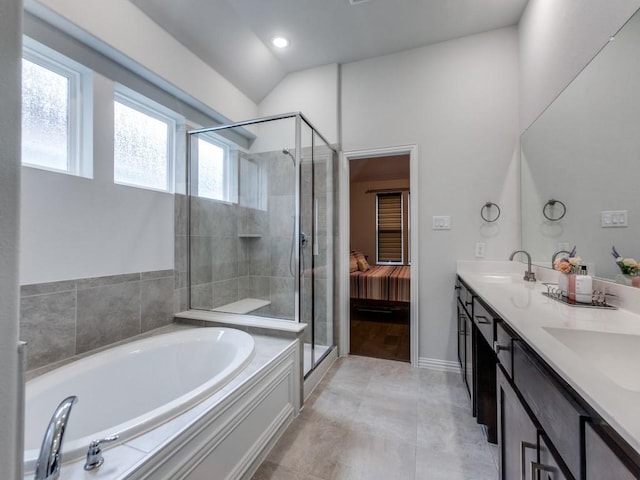 ensuite bathroom featuring double vanity, a sink, a garden tub, and a stall shower