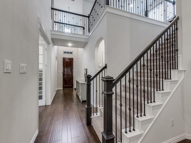 foyer entrance featuring baseboards, a high ceiling, and hardwood / wood-style floors