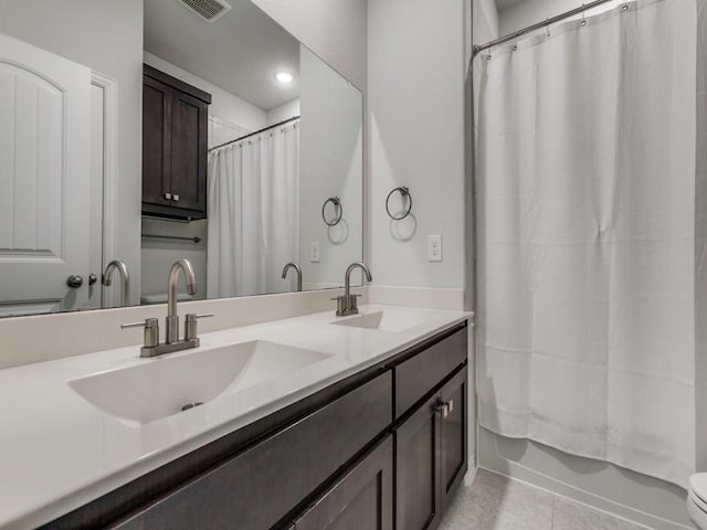 full bath featuring a sink, tile patterned flooring, double vanity, and visible vents