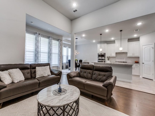 living area featuring visible vents, recessed lighting, and light wood finished floors