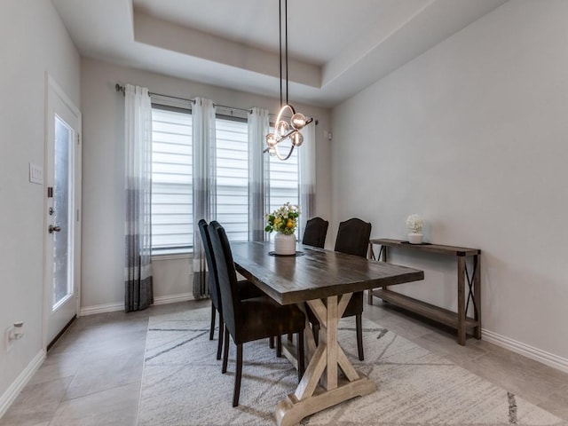 dining space with light tile patterned floors, baseboards, plenty of natural light, and a notable chandelier