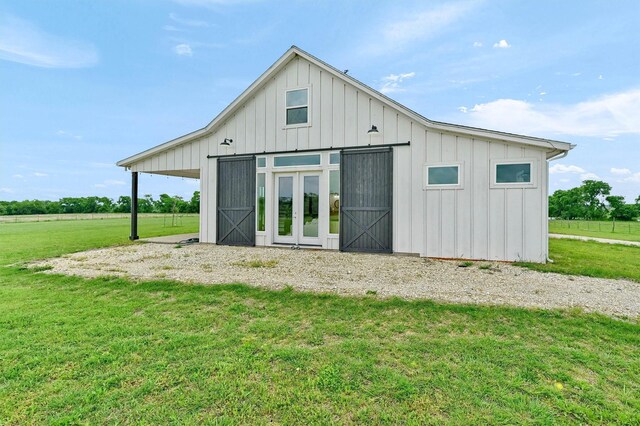back of house with an outbuilding, board and batten siding, and a yard
