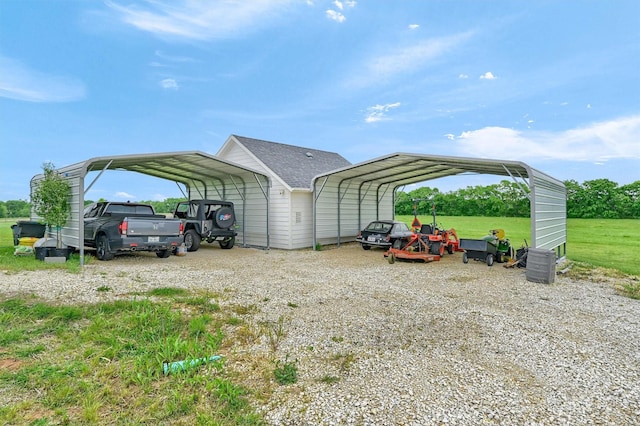 view of vehicle parking with a detached carport and gravel driveway