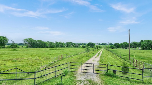 exterior space featuring fence, a lawn, and a rural view