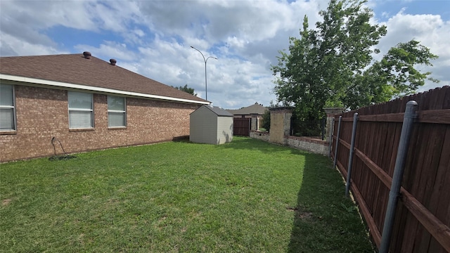 view of yard with a fenced backyard, a storage unit, and an outdoor structure