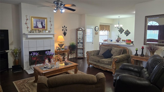 living area featuring wood finished floors, ceiling fan with notable chandelier, and a fireplace
