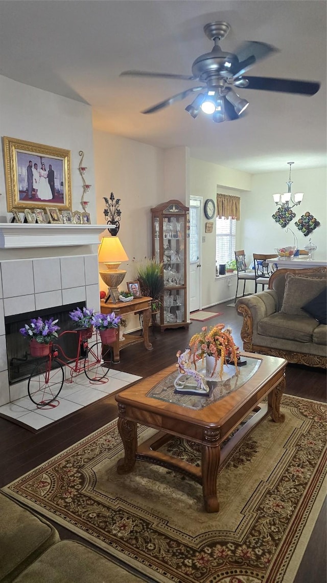 living area featuring a ceiling fan, wood finished floors, and a fireplace