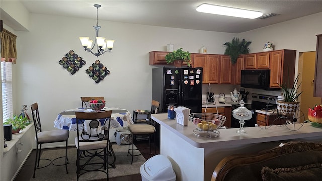 kitchen featuring visible vents, brown cabinetry, a peninsula, a chandelier, and black appliances