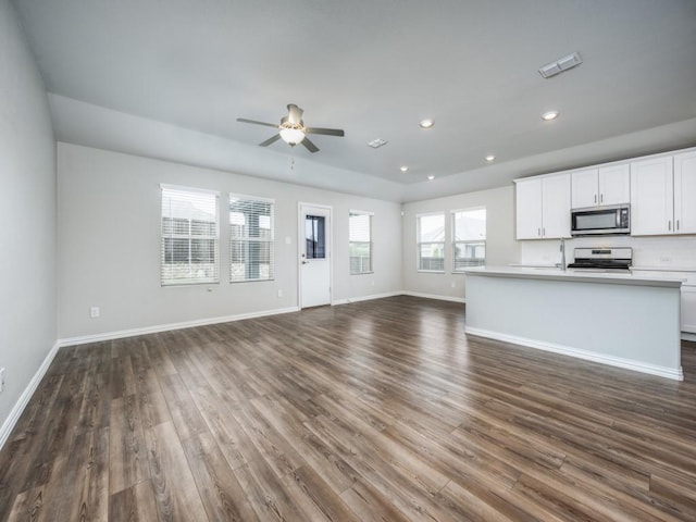 3517 Triumph Dr, Denton, TX 76207 - unfurnished living room featuring a ceiling fan, baseboards, dark wood-style floors, and a sink