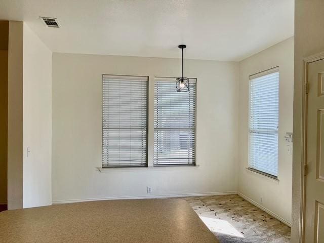 unfurnished dining area featuring visible vents and baseboards