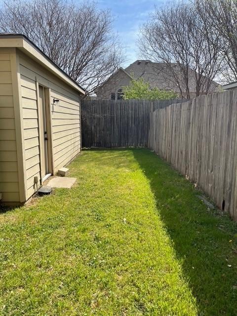 view of yard with an outbuilding and a fenced backyard