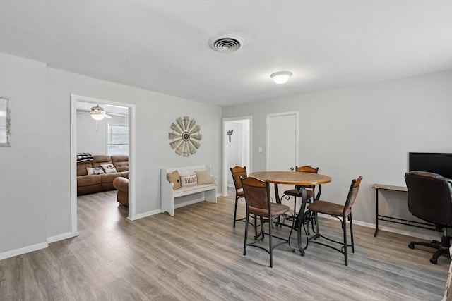 dining space featuring baseboards, light wood-type flooring, and visible vents