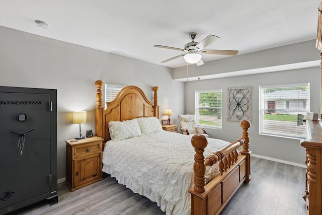 bedroom with baseboards, light wood finished floors, and ceiling fan