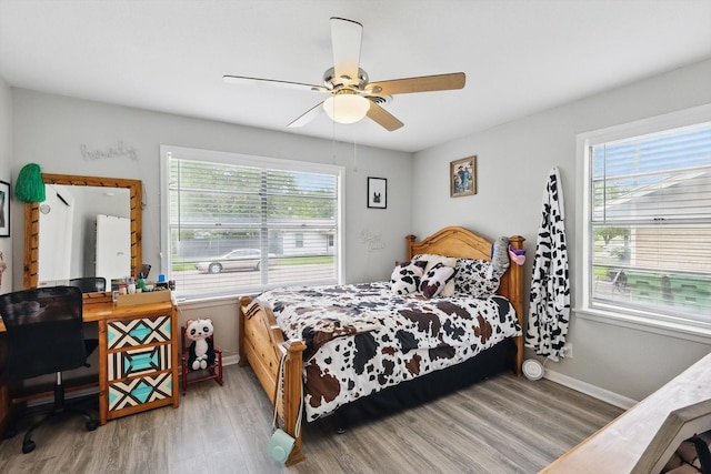 bedroom featuring baseboards, ceiling fan, and wood finished floors