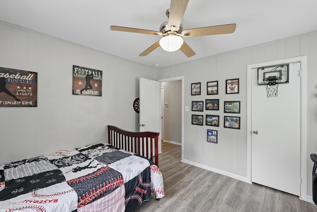 bedroom featuring baseboards, ceiling fan, and wood finished floors