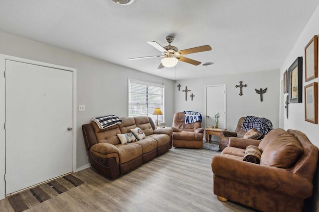 living area with ceiling fan, light wood finished floors, and visible vents