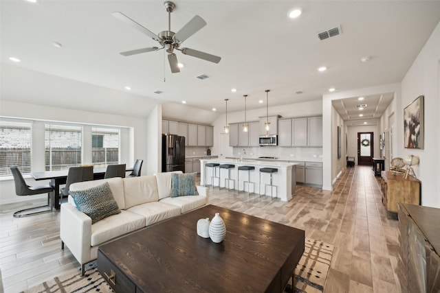 living area featuring baseboards, a ceiling fan, recessed lighting, and visible vents