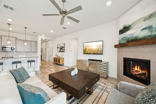 living area featuring recessed lighting, a ceiling fan, light wood-type flooring, and visible vents