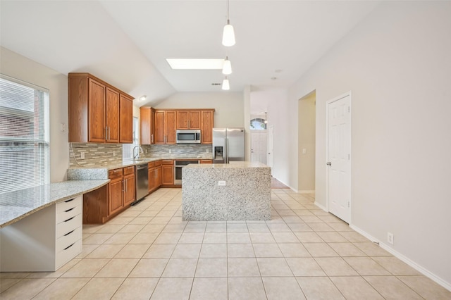 kitchen with light stone countertops, lofted ceiling with skylight, light tile patterned floors, appliances with stainless steel finishes, and backsplash