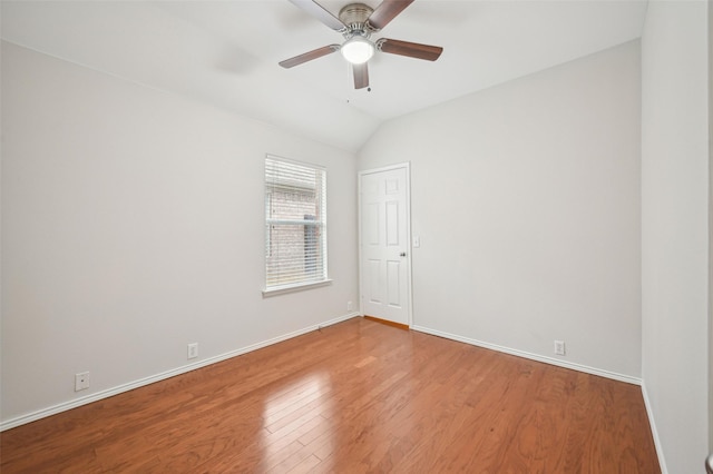 empty room featuring baseboards, lofted ceiling, wood finished floors, and ceiling fan