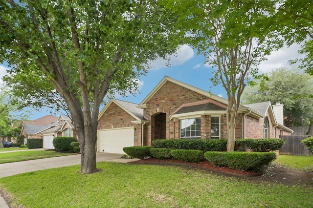 single story home featuring fence, a front yard, brick siding, concrete driveway, and an attached garage