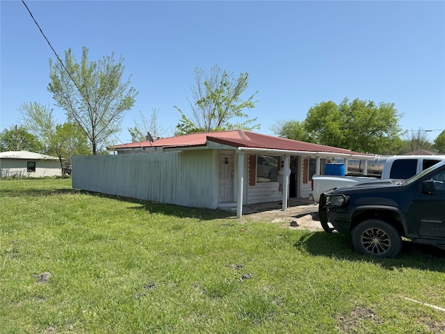 view of home's exterior featuring a yard and metal roof