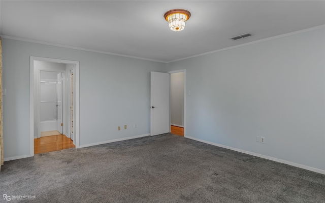 unfurnished bedroom with carpet floors, baseboards, visible vents, and ornamental molding