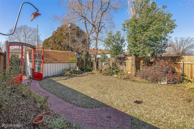 view of yard with a fenced backyard and an outbuilding