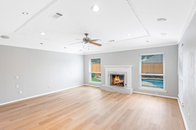 unfurnished living room featuring light wood-style flooring, recessed lighting, a high end fireplace, visible vents, and ornamental molding