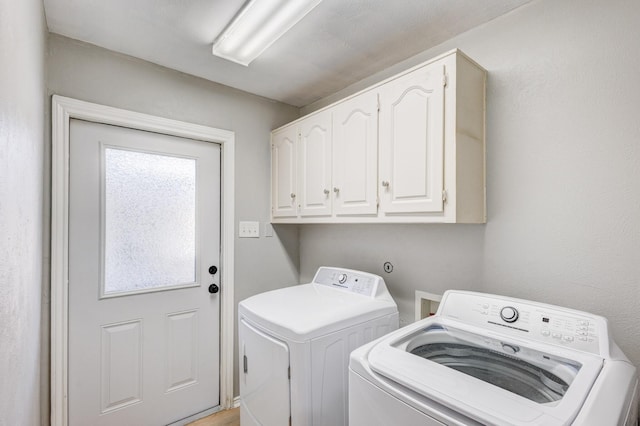 clothes washing area with independent washer and dryer and cabinet space