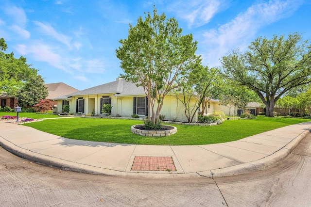 ranch-style home featuring brick siding and a front yard