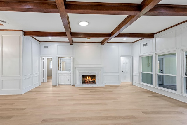 unfurnished living room featuring visible vents, a decorative wall, beam ceiling, coffered ceiling, and light wood-style flooring