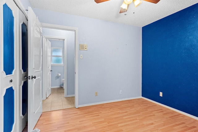 1013 Briarcreek Dr, Arlington, TX 76012 - unfurnished bedroom with light wood finished floors, a textured ceiling, a ceiling fan, baseboards, and a closet