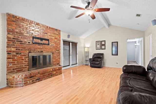 1013 Briarcreek Dr, Arlington, TX 76012 - living area featuring visible vents, wood finished floors, a fireplace, ceiling fan, and vaulted ceiling with beams