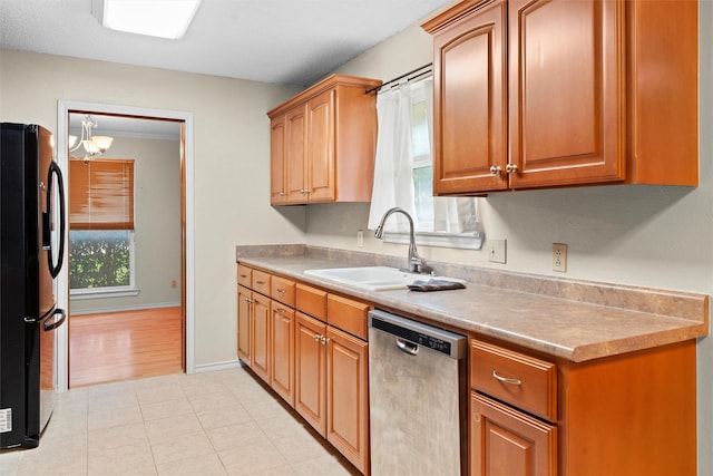 1013 Briarcreek Dr, Arlington, TX 76012 - kitchen with freestanding refrigerator, light countertops, a chandelier, a sink, and dishwasher