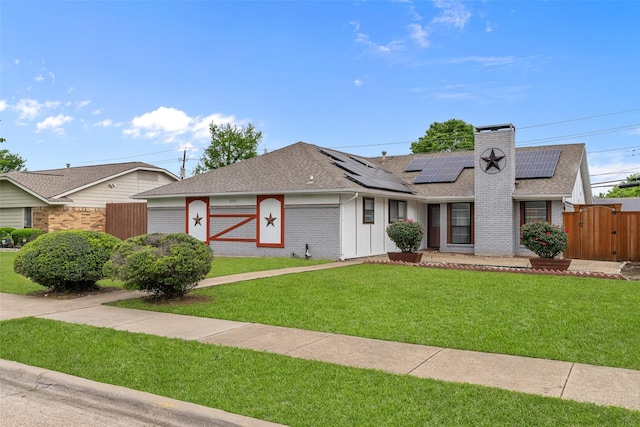ranch-style home with a shingled roof, solar panels, a gate, and a front lawn