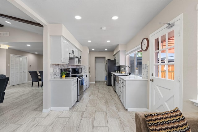 kitchen featuring light countertops, backsplash, electric range, and visible vents