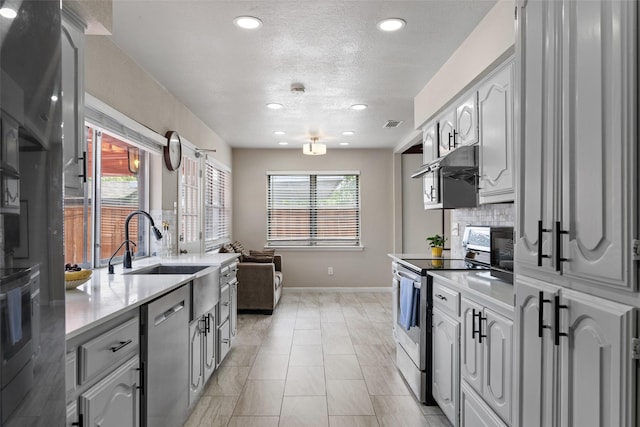 kitchen with decorative backsplash, baseboards, recessed lighting, light countertops, and appliances with stainless steel finishes