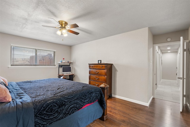 bedroom featuring baseboards, a ceiling fan, a textured ceiling, and hardwood / wood-style floors