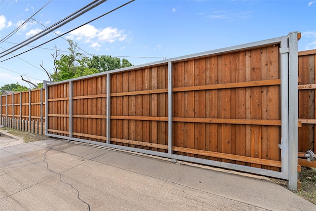 view of gate with fence and a patio area