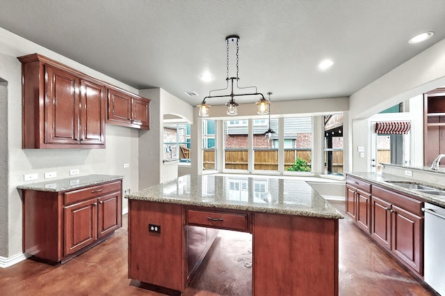 kitchen with a sink, light stone counters, plenty of natural light, and dishwasher