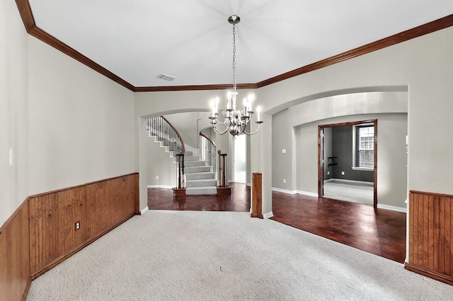 unfurnished dining area featuring crown molding, visible vents, stairs, a chandelier, and arched walkways