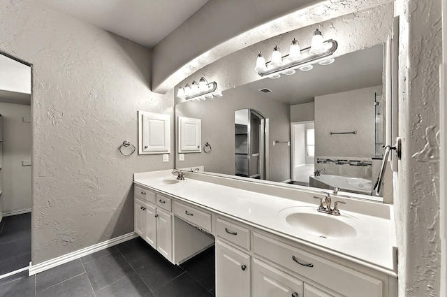 full bathroom featuring tile patterned flooring, a sink, a textured wall, and double vanity