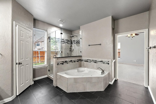 bathroom with a textured wall, tile patterned flooring, a whirlpool tub, baseboards, and a shower stall