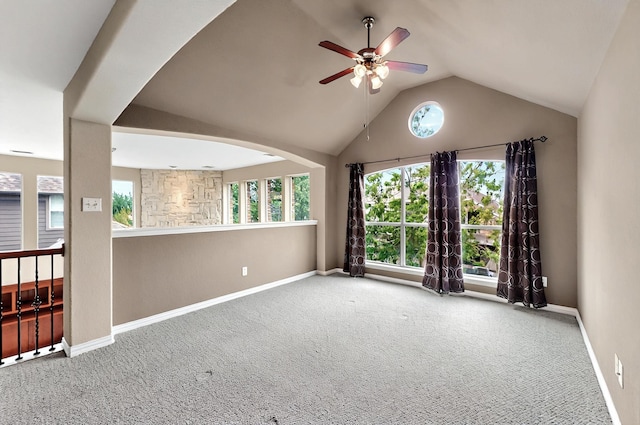 carpeted spare room with a ceiling fan, baseboards, vaulted ceiling, and a wealth of natural light